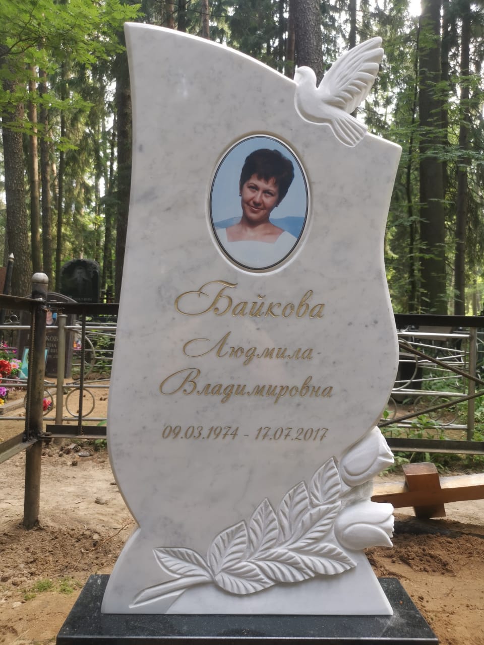 Памятник с розами и голубем