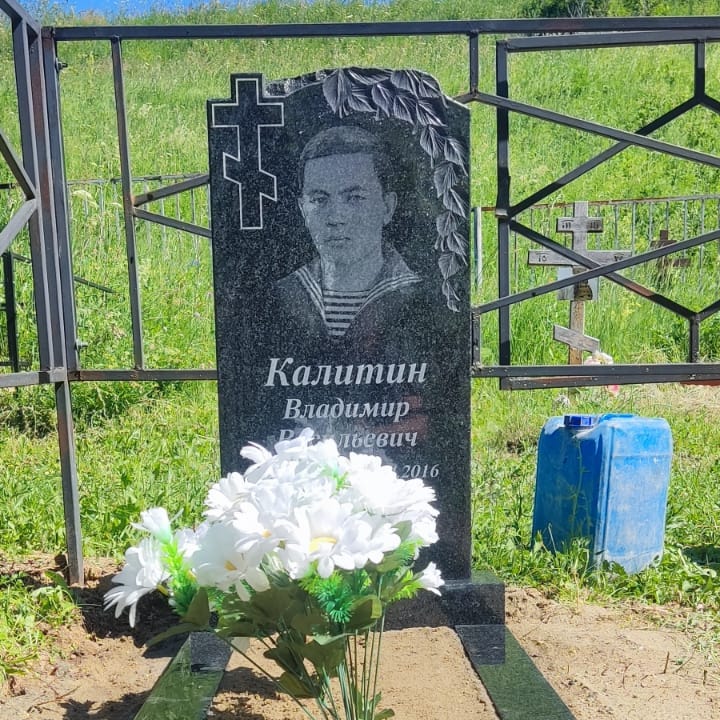 Памятник с веткой березы и крестом